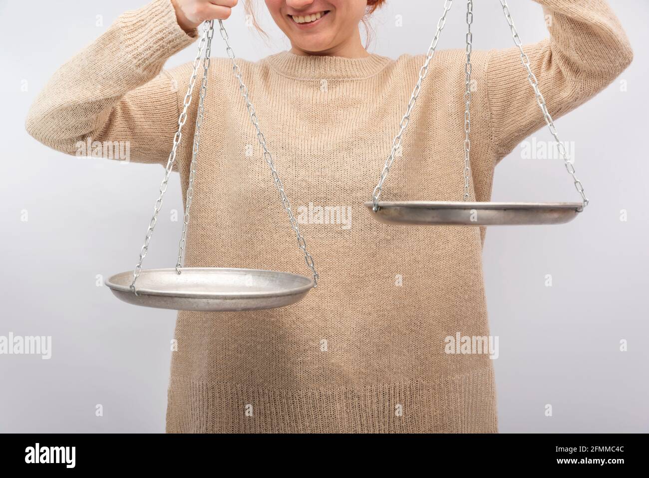 Smile woman is holding the empty scales. Equilibrium, justice concept ...