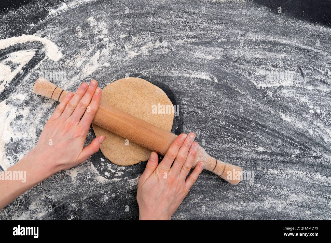 Wome's hands rolling out dough for shortbread cookies. Homemade baking Stock Photo