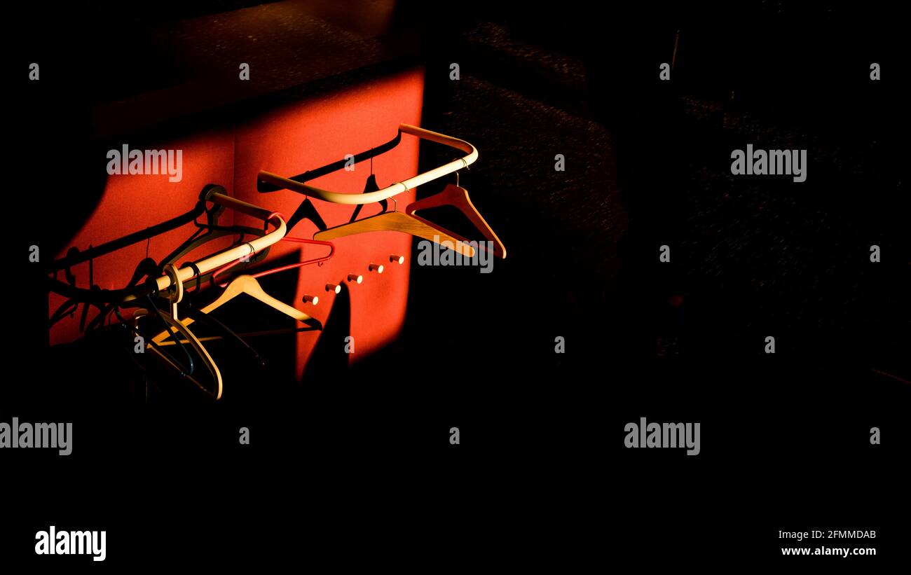 Empty hangers in sunlight with red and black backgrounds. Abstract and color image. Stock Photo