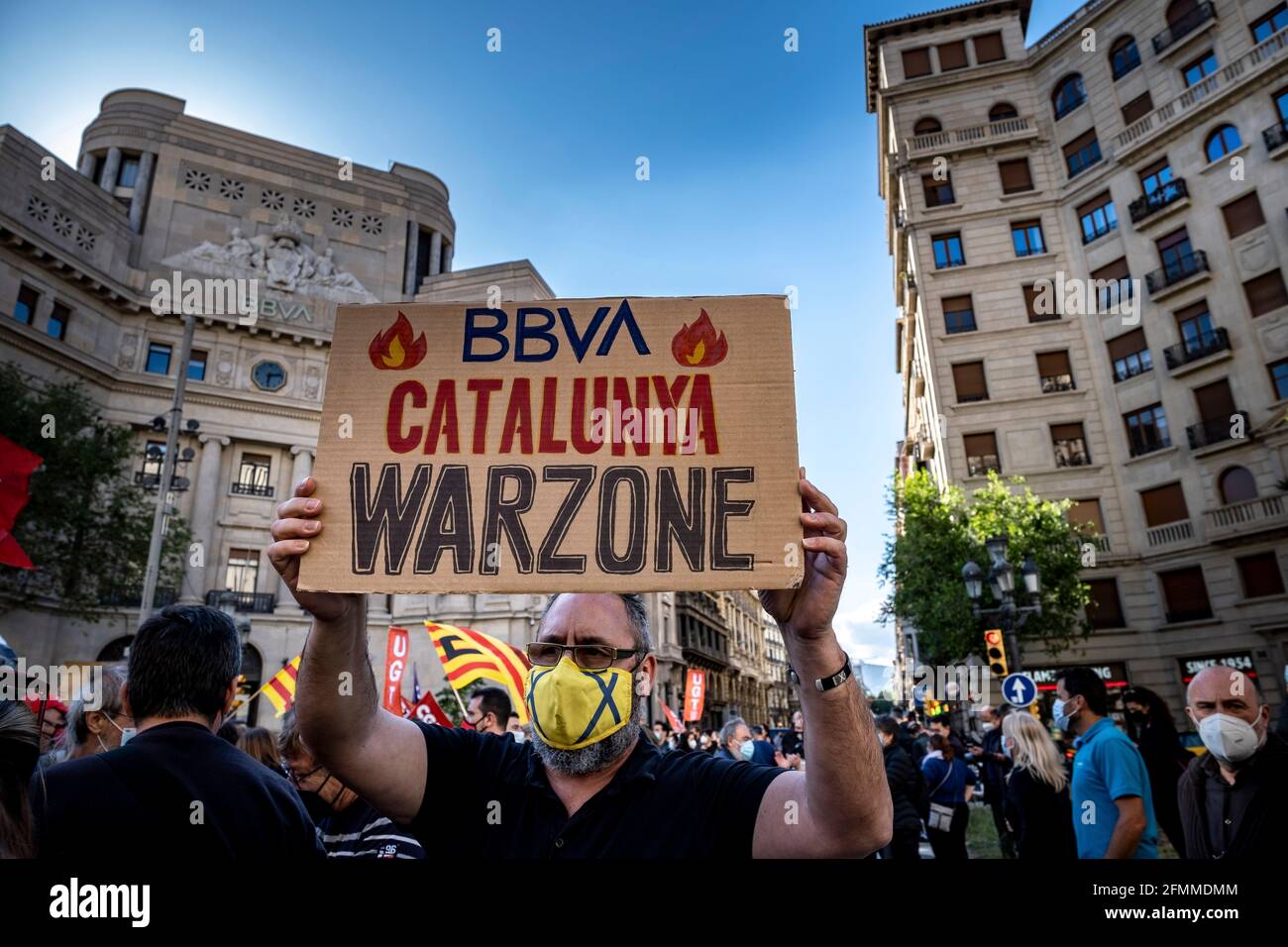 Barcelona, Spain. 10th May, 2021. A protester holds a placard declaring Catalonia as a War Zone during the demonstration in front of the bank's headquarters in Vía Laietana.Summoned by the banking unions, hundreds of Banco Bilbao Vizcaya Argentaria (BBVA) bank workers have gathered in front of the headquarters in Vía Laietana to protest the Employment Regulation File (ERE) that the entity wants to apply with the dismissal of more than 3,000 workers. (Photo by Paco Freire/SOPA Images/Sipa USA) Credit: Sipa USA/Alamy Live News Stock Photo