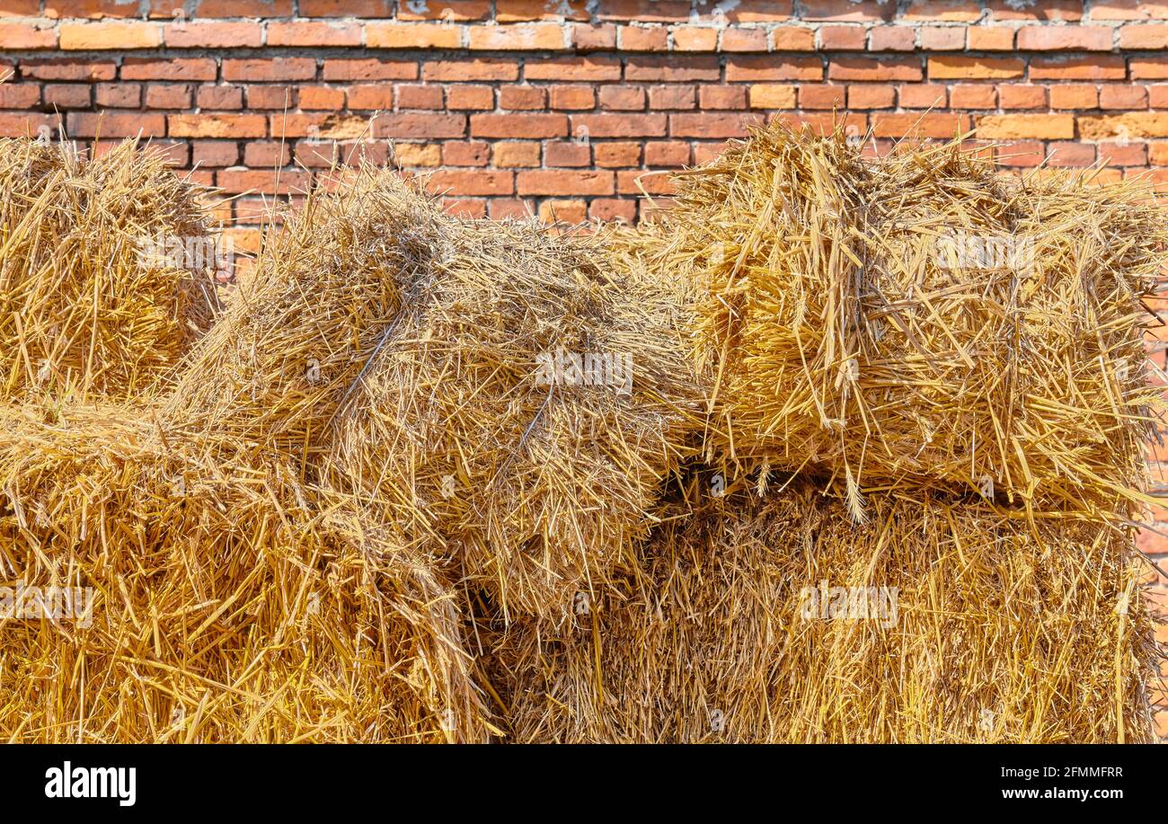 Haystack in front of an old brick building. Stock Photo