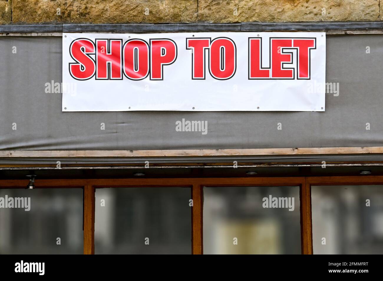 Large banner on the outside of a business which has closed down advertising a shop to let. No people. Stock Photo