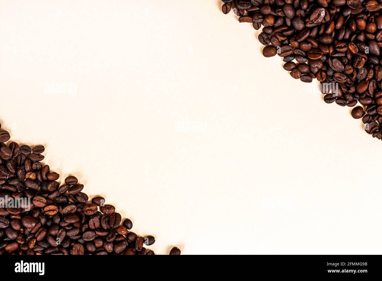 Fresh roasted brown coffee beans as a frame with copy space on light background. Stock Photo