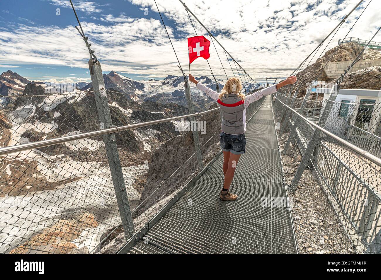 bord Vorming mout Woman with Swiss flag on Titlis cliff walk suspension bridge. Top of Titlis  mountain with glacier in the Uri Alps. Viewpoint 3028 m in cantons of Stock  Photo - Alamy