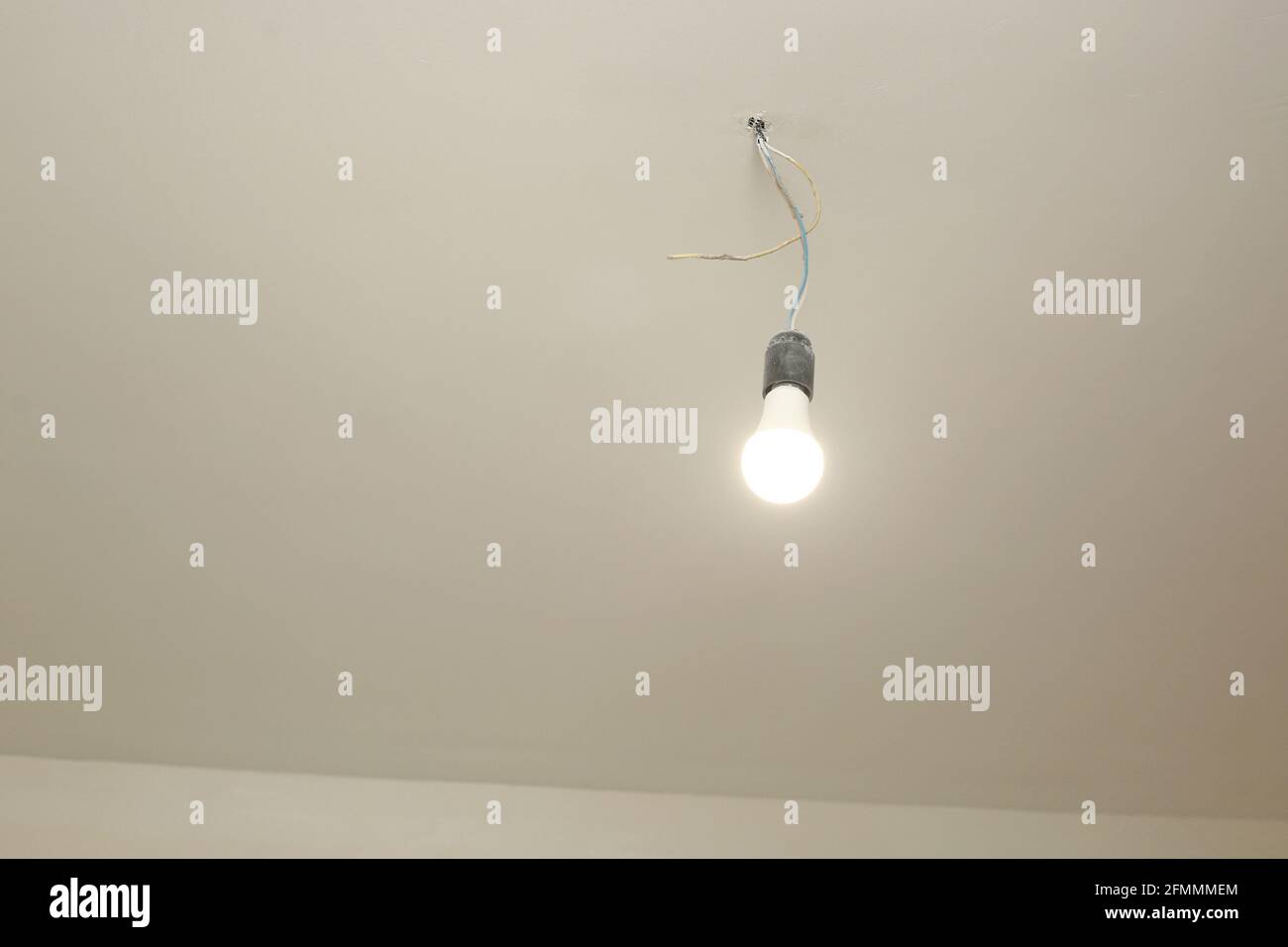The light bulb on the white ceiling is on. repair Stock Photo - Alamy
