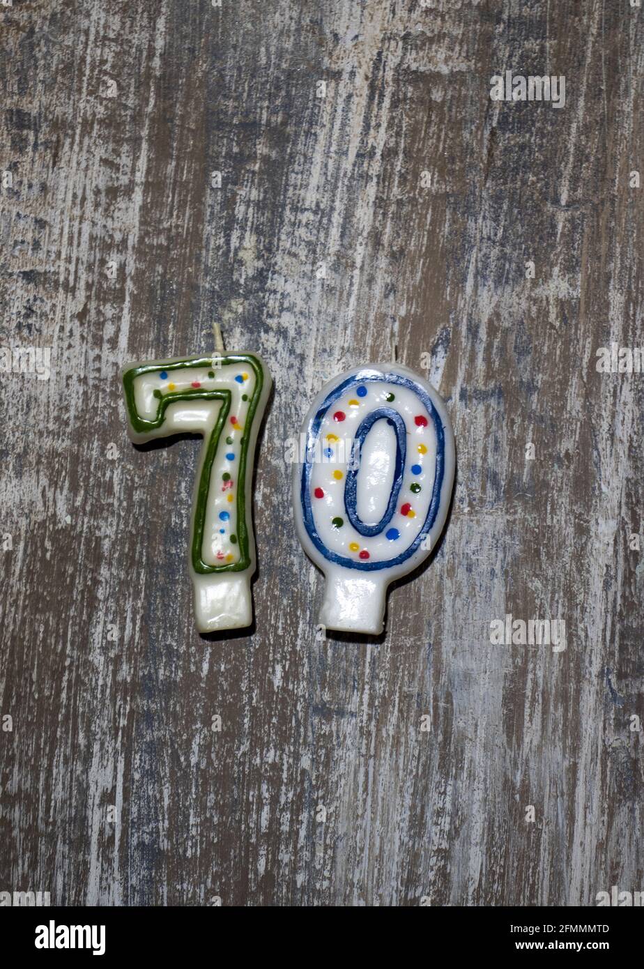 Vertical shot of birthday candles with the number 70 on a wooden background Stock Photo