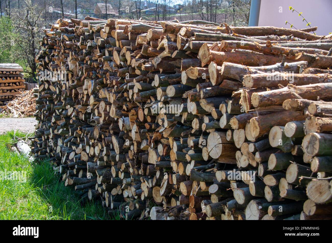 Fuel for stove heating. Country life. Wooden firewood stacked wall