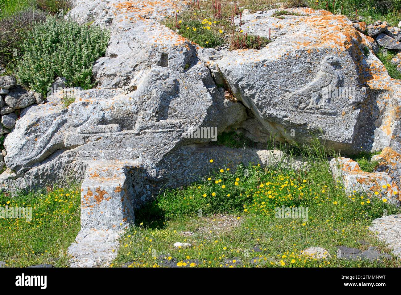 Carved lion and raven on stone ruins of Ancient Thera on Messavouno mountain, Santorini, Greece Stock Photo