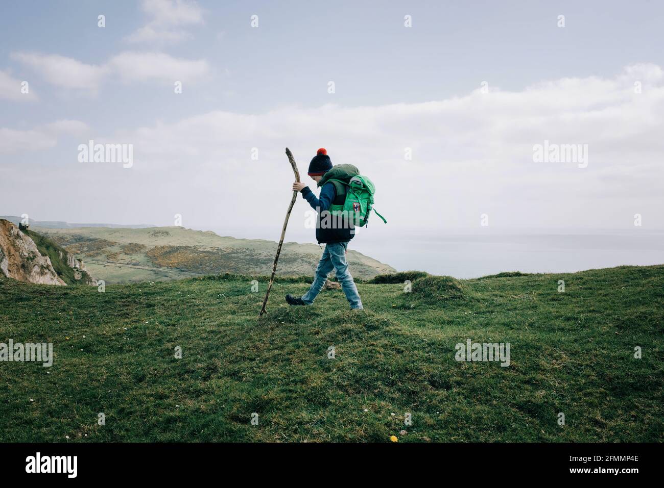 boy hiking along the Jurassic coast with a walking stick exploring