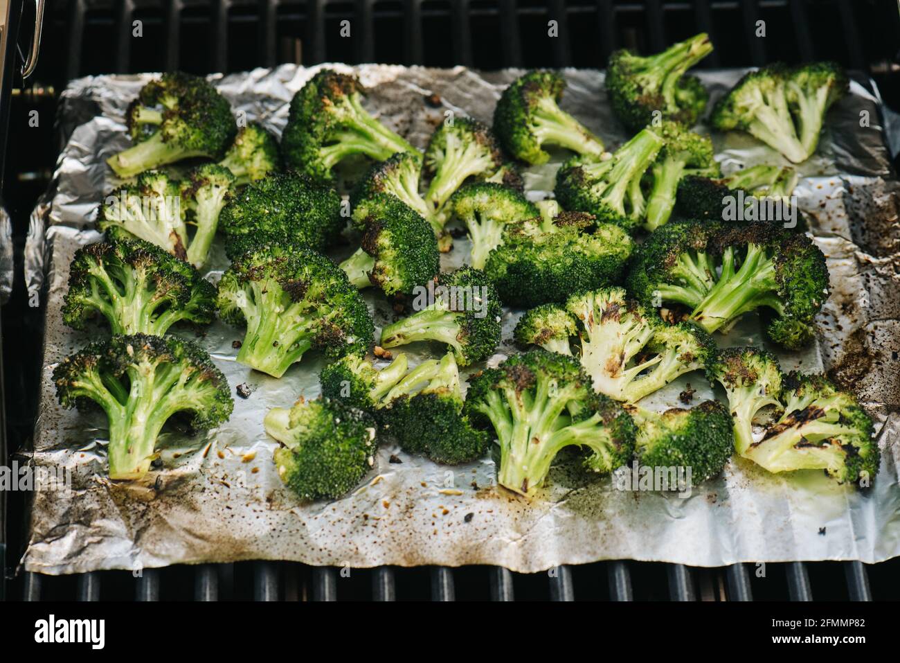 Garlic cooking over foil on an outdoor gas grill Stock Photo Alamy