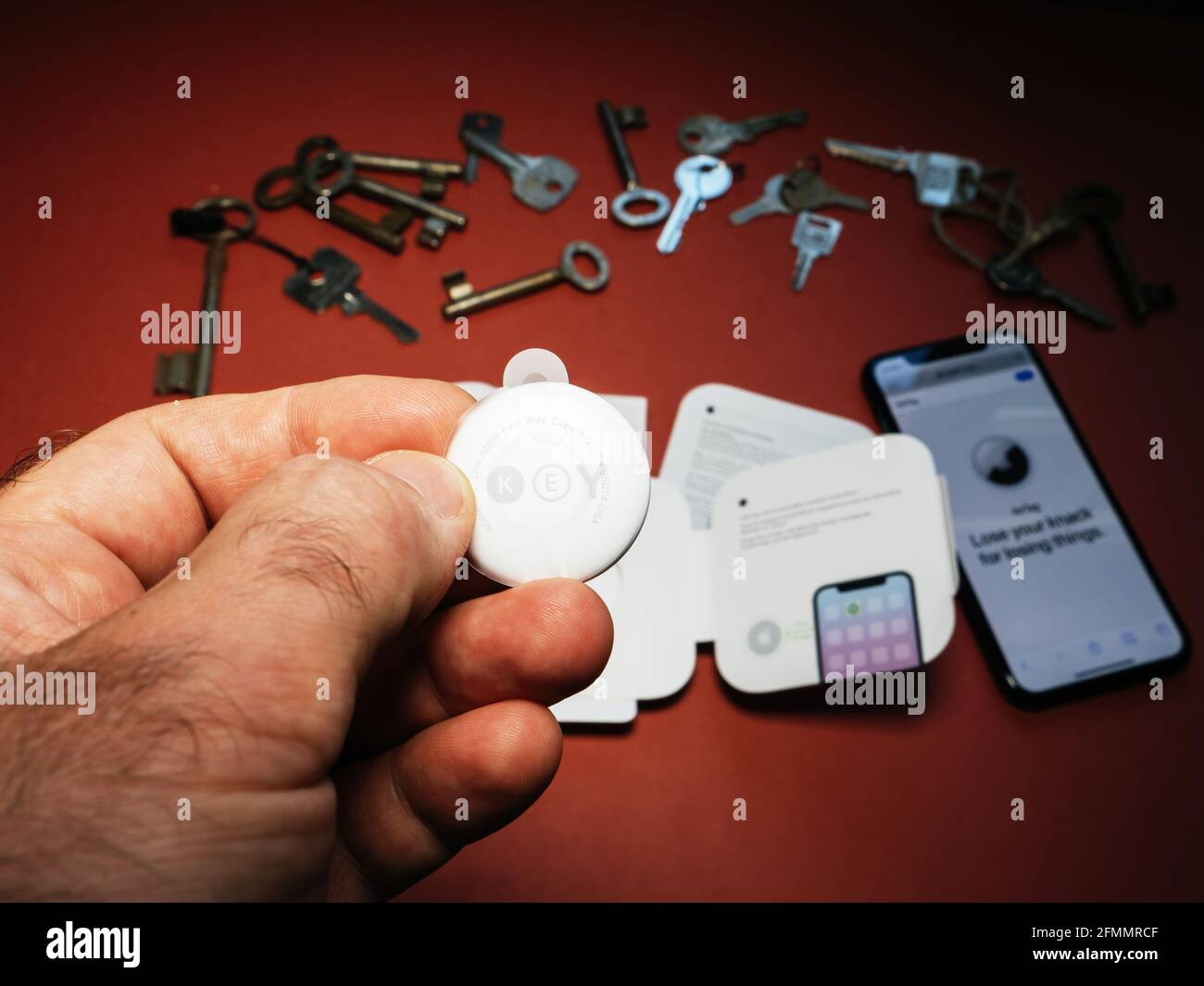 Man pov looking at AirTag with printed emoji key Stock Photo