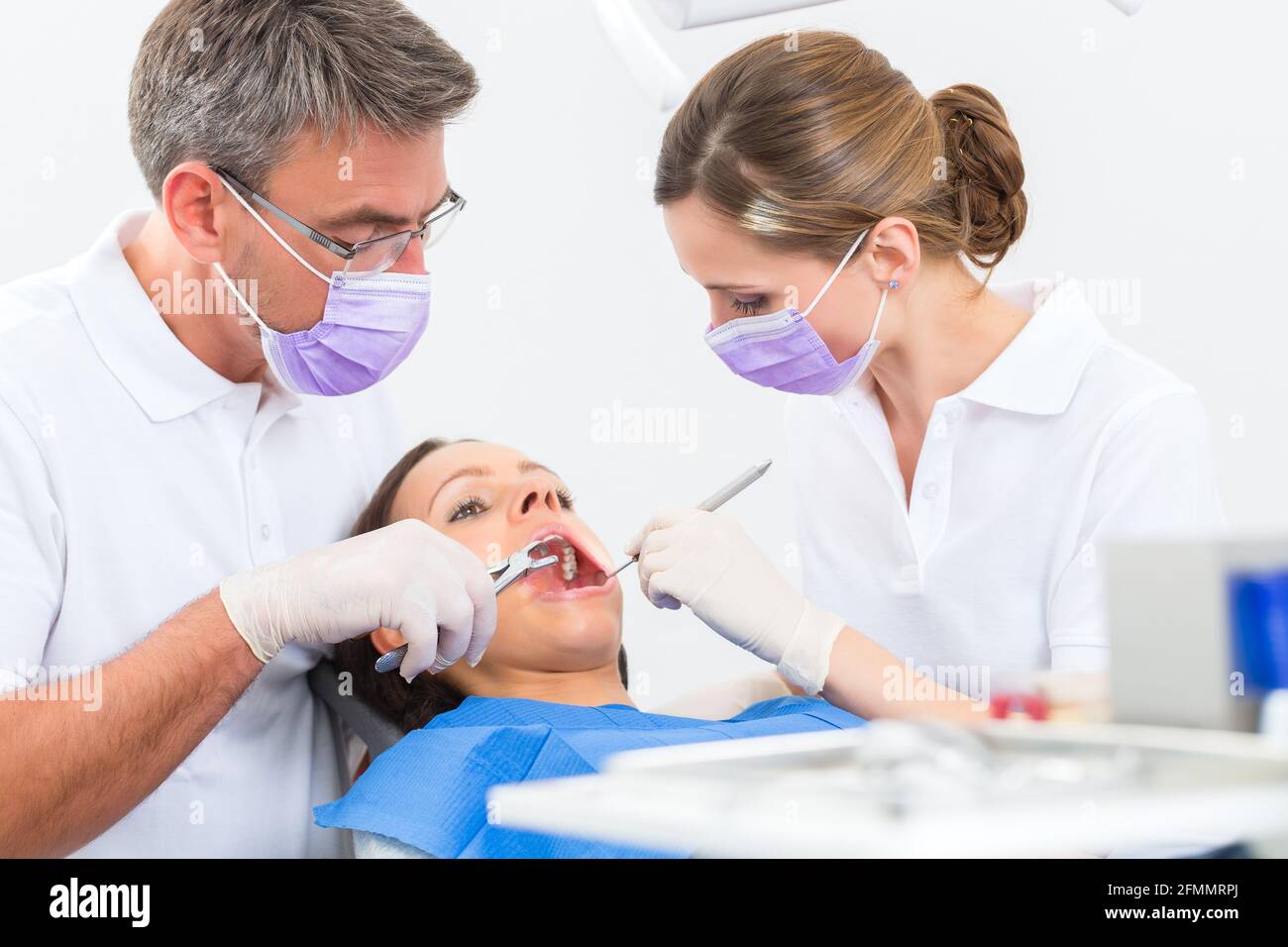 Female patient with dentist and assistant in a dental treatment