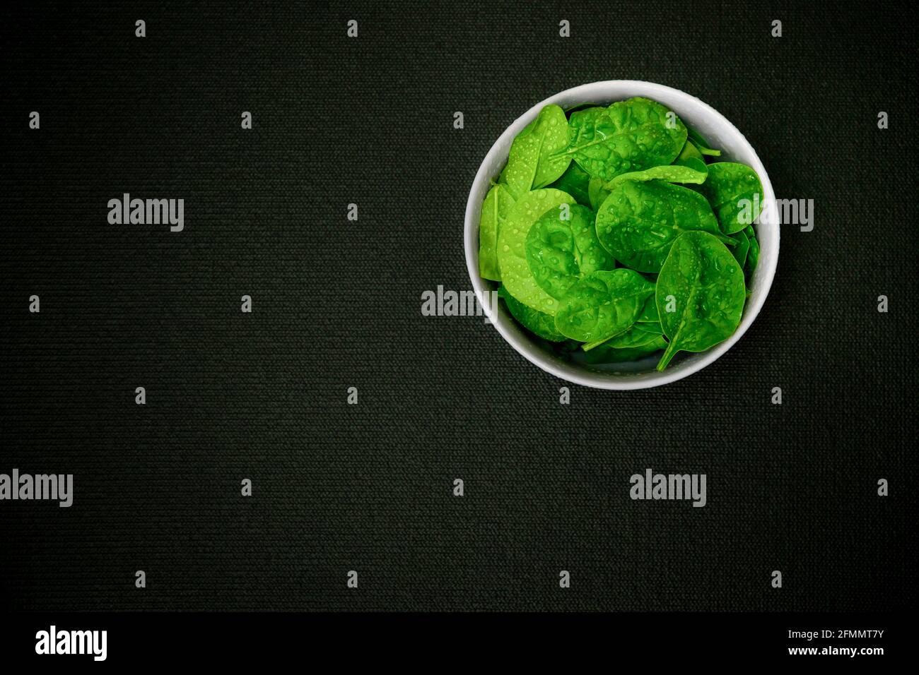 Fresh baby spinach in a black bowl Stock Photo