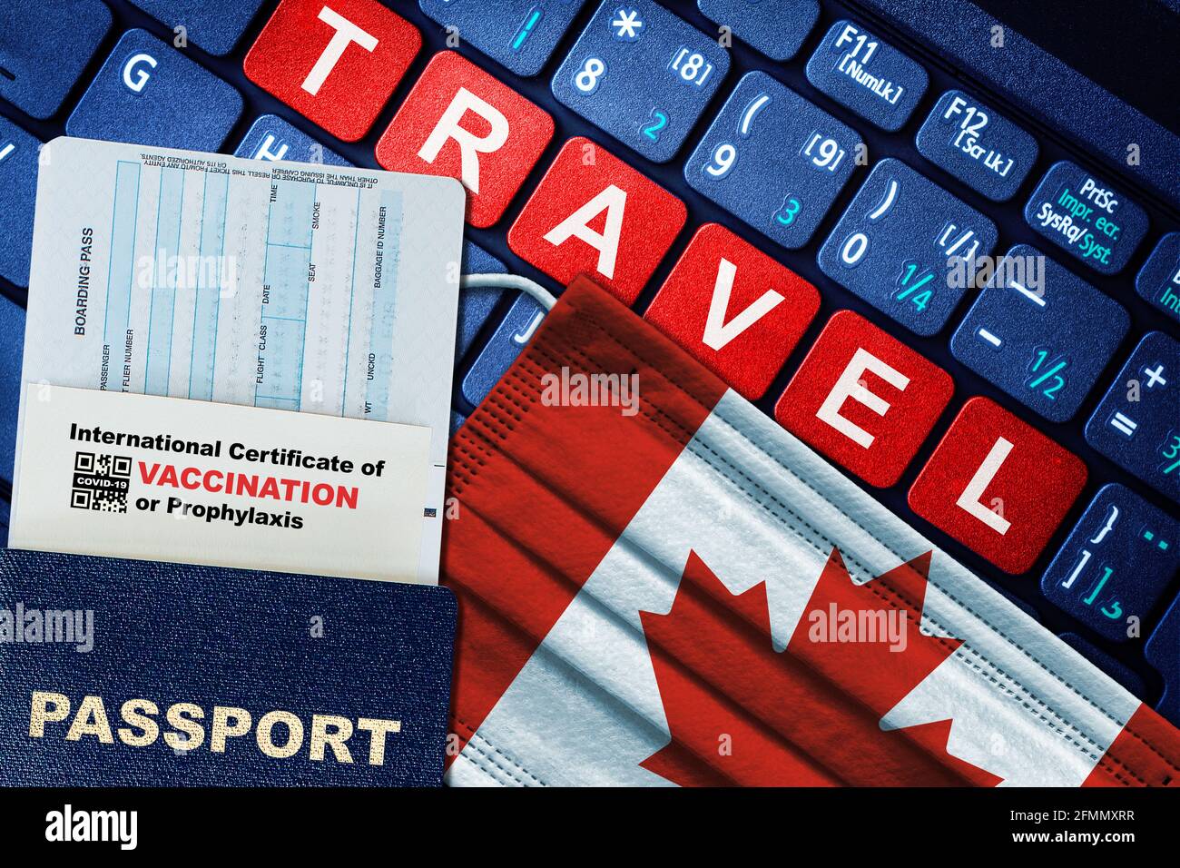 Canada new normal travel concept with passport, boarding pass, face mask with Canadian flag and certificate of COVID-19 vaccination on keyboard. Stock Photo