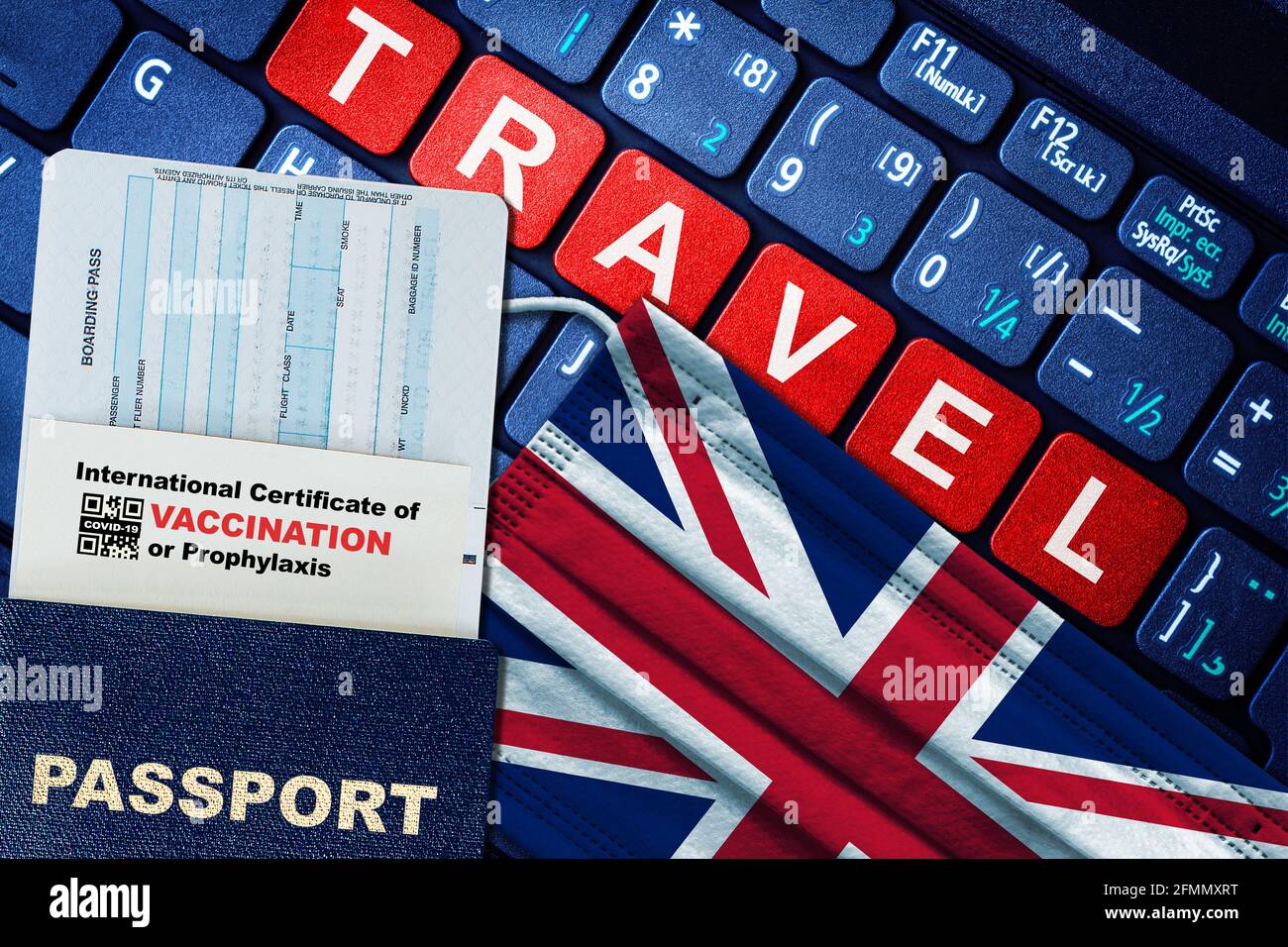UK new normal travel concept with passport, boarding pass, face mask with UK flag and certificate of COVID-19 vaccination on keyboard. Vaccine passpor Stock Photo