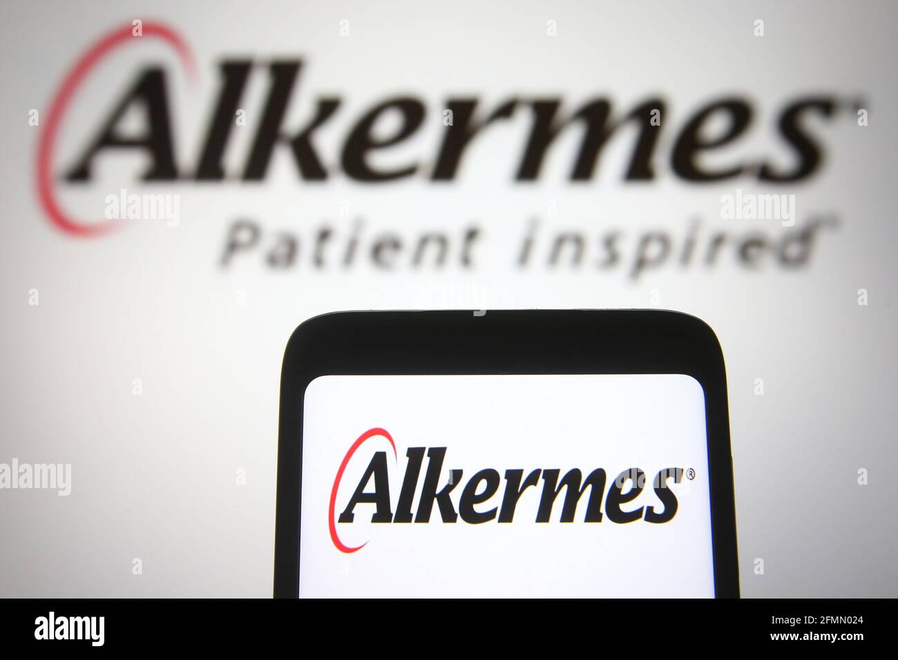 In this photo illustration the Alkermes logo of a biopharmaceutical company is seen on a smartphone and a pc screen. Stock Photo