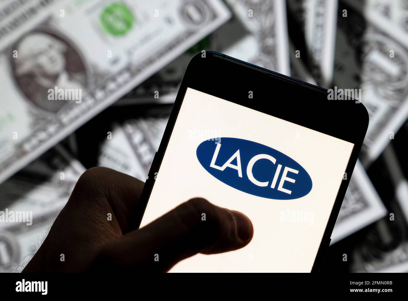 China. 21st Apr, 2021. In this photo illustration the French computer hardware company Lacie logo seen displayed on a smartphone with USD (United States dollar) currency in the background. Credit: Budrul Chukrut/SOPA Images/ZUMA Wire/Alamy Live News Stock Photo