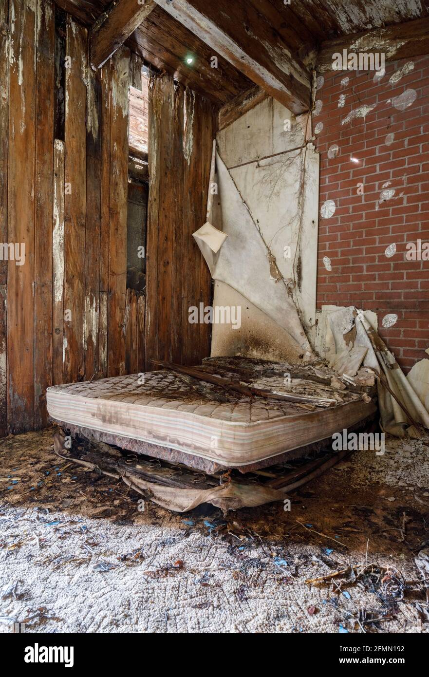 An abandoned motel room with extreme rot starting to take hold. Stock Photo