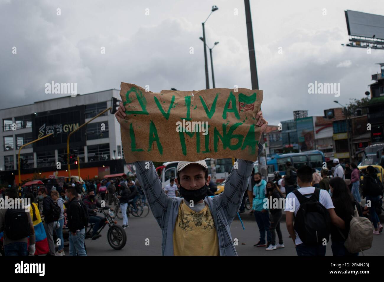 Bogota, Colombia, May 10, 2021, A demonstrator holds a sign in support of the MINGA Indigena movement, that was attacked by armed people in Cali during the weekend as Bogota faces its 13 day of anti-government protests against the Health Reform and Police Brutality cases that rise to over 30 dead across the country since the National Strike begun. In Bogota, Colombia on May 10, 2021 Stock Photo