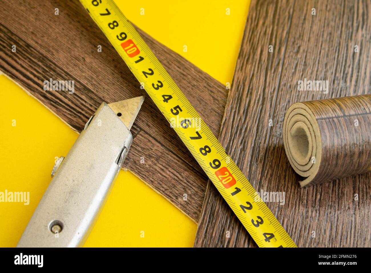 Linoleum tape measure and knife on an isolated background. A piece of linoleum. Measurement and