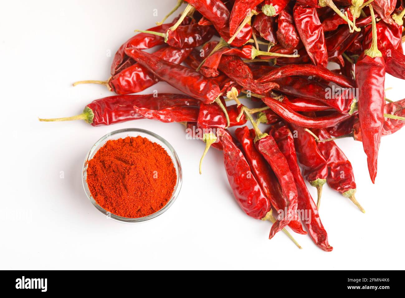 Dried red chilli and red chilli powder in glass bowl and wooden spoon