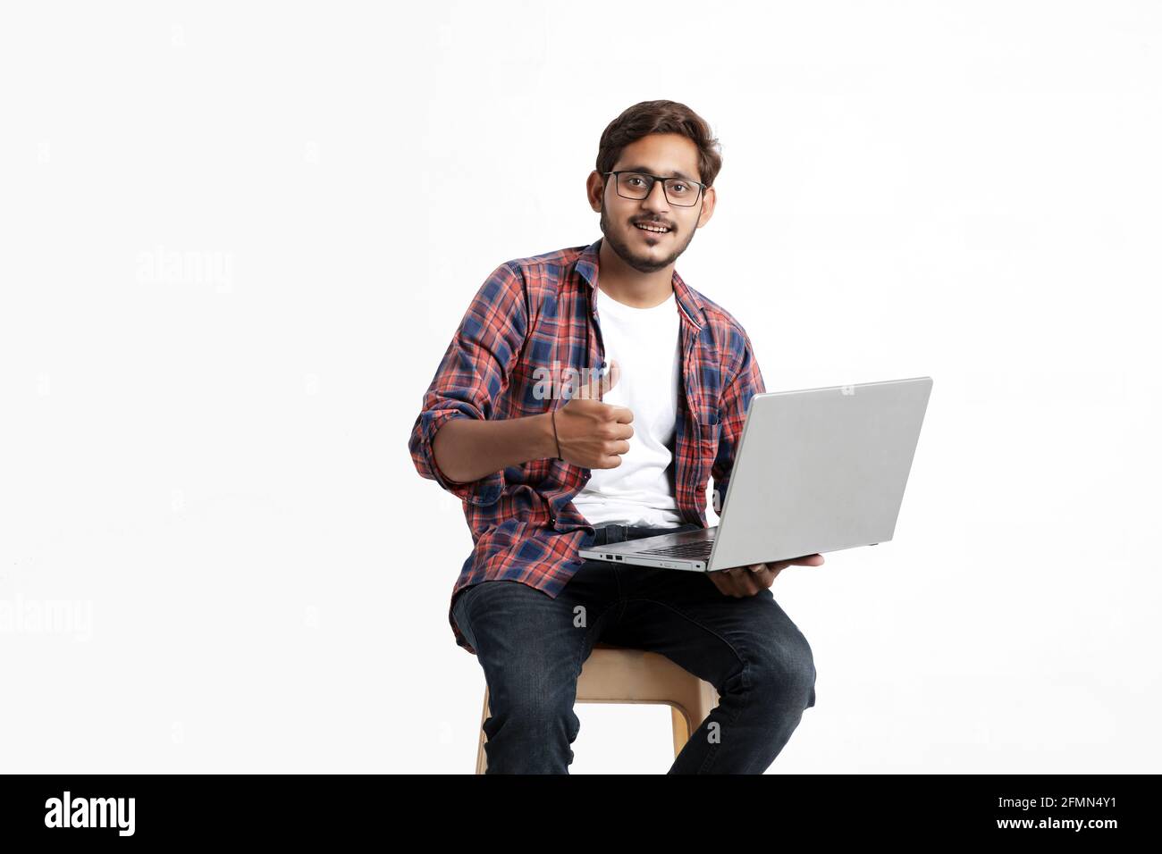 Indian college student using laptop on white background. Stock Photo