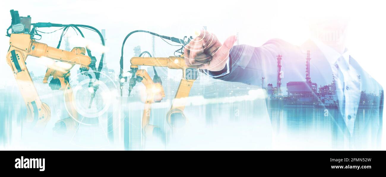 Mechanized industry robot arm and factory worker double exposure . Concept of robotics technology for industrial revolution and automated Stock Photo