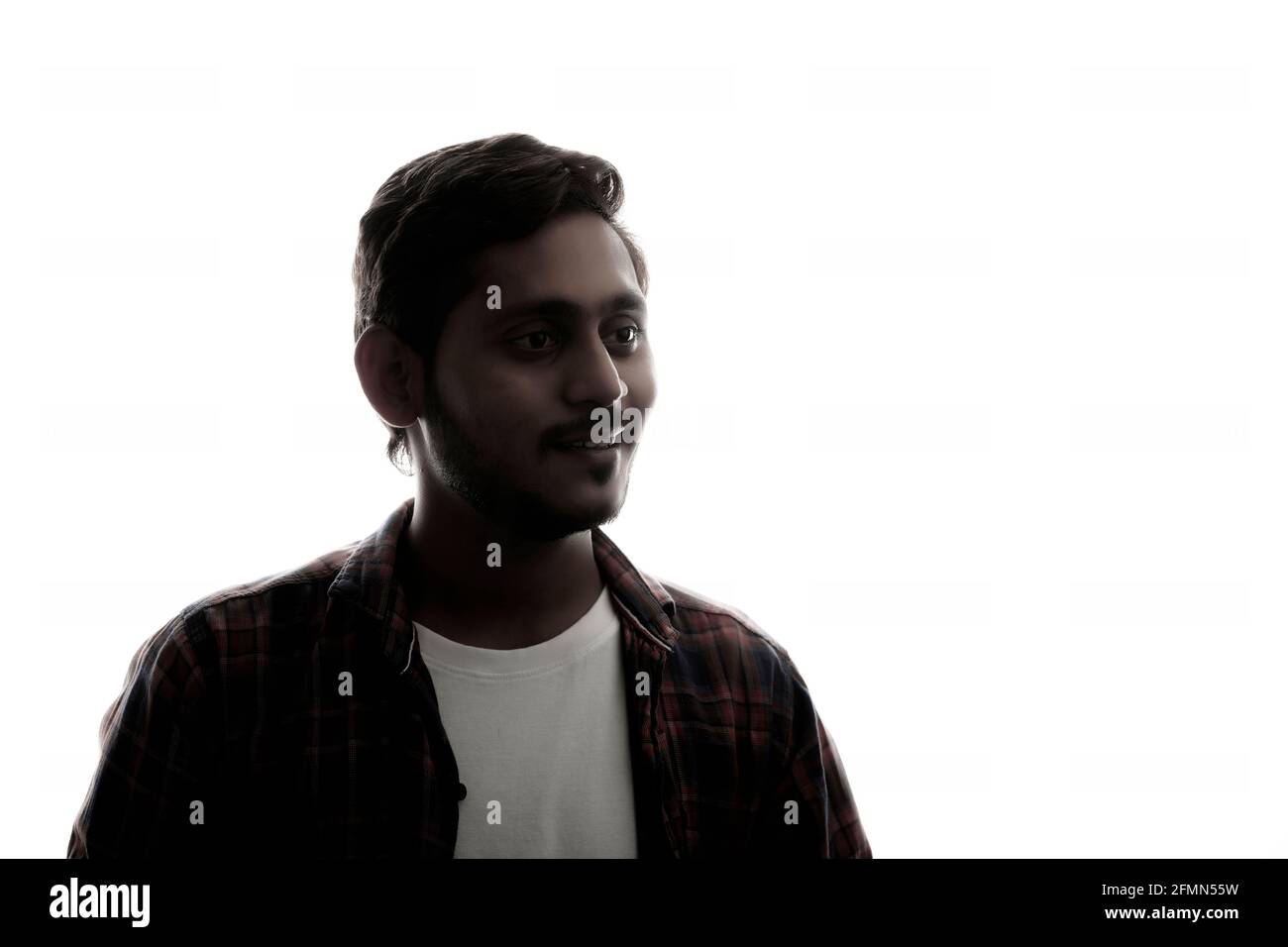 Young Indian man standing on white background. Stock Photo