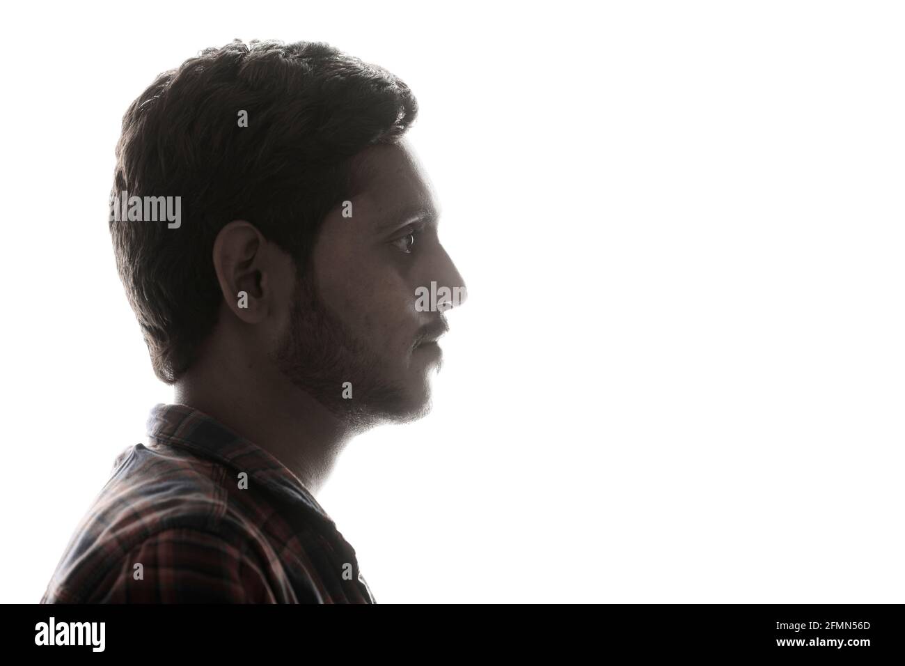Young Indian man standing on white background. Stock Photo