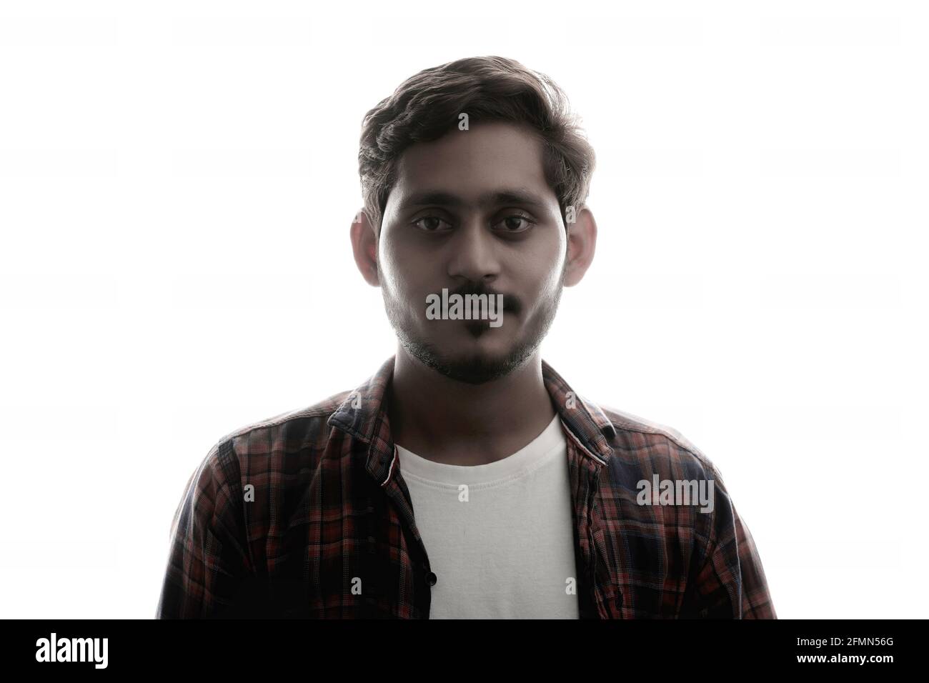 Young Indian man standing on white background. Stock Photo