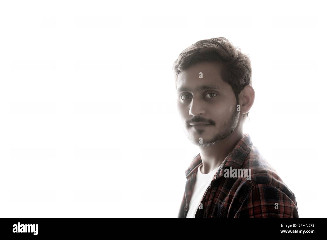 Young Indian man standing on white background. Stock Photo