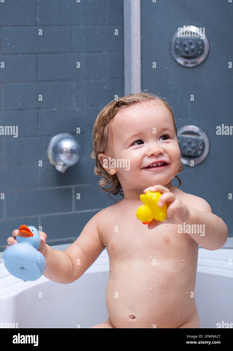 Child in shower. Cute baby boy enjoying bath and bathed in the bathroom