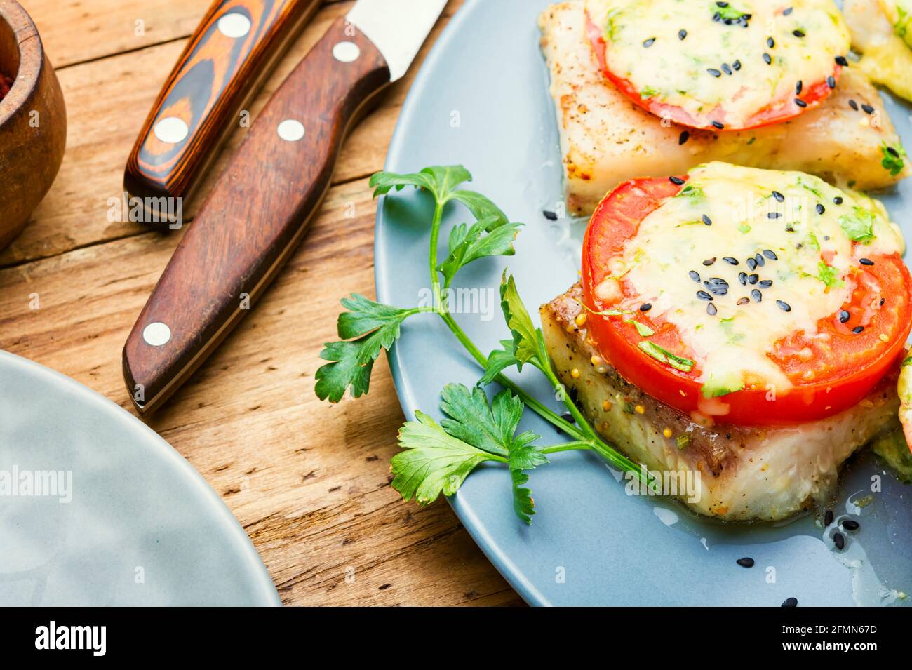 Baked fish with cheese and tomato.Roasted pangasius Stock Photo