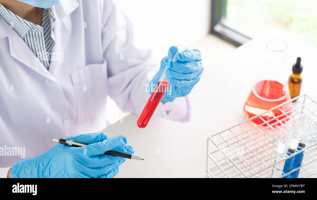 Young Asian scientist Working looking through a microscope doing ...