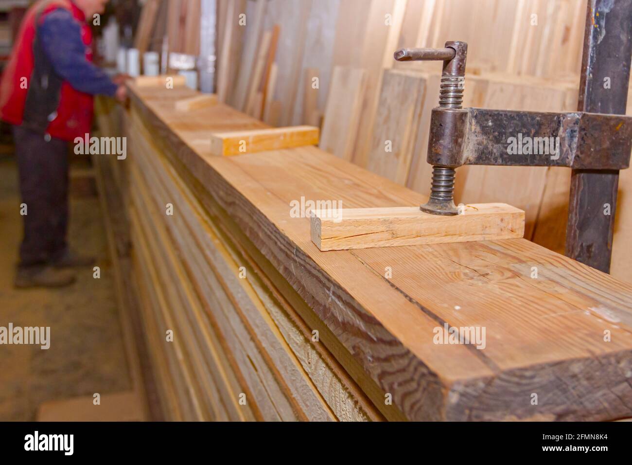 Process of drying glue in the manual production of wooden profiles in carpentry. Clamp tool for