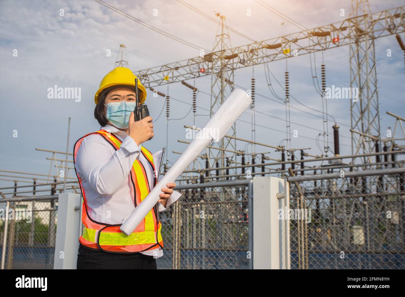 Women Engineer hold blueprint , Worker wear mask protect covid19 , Women use Radio communication Stock Photo
