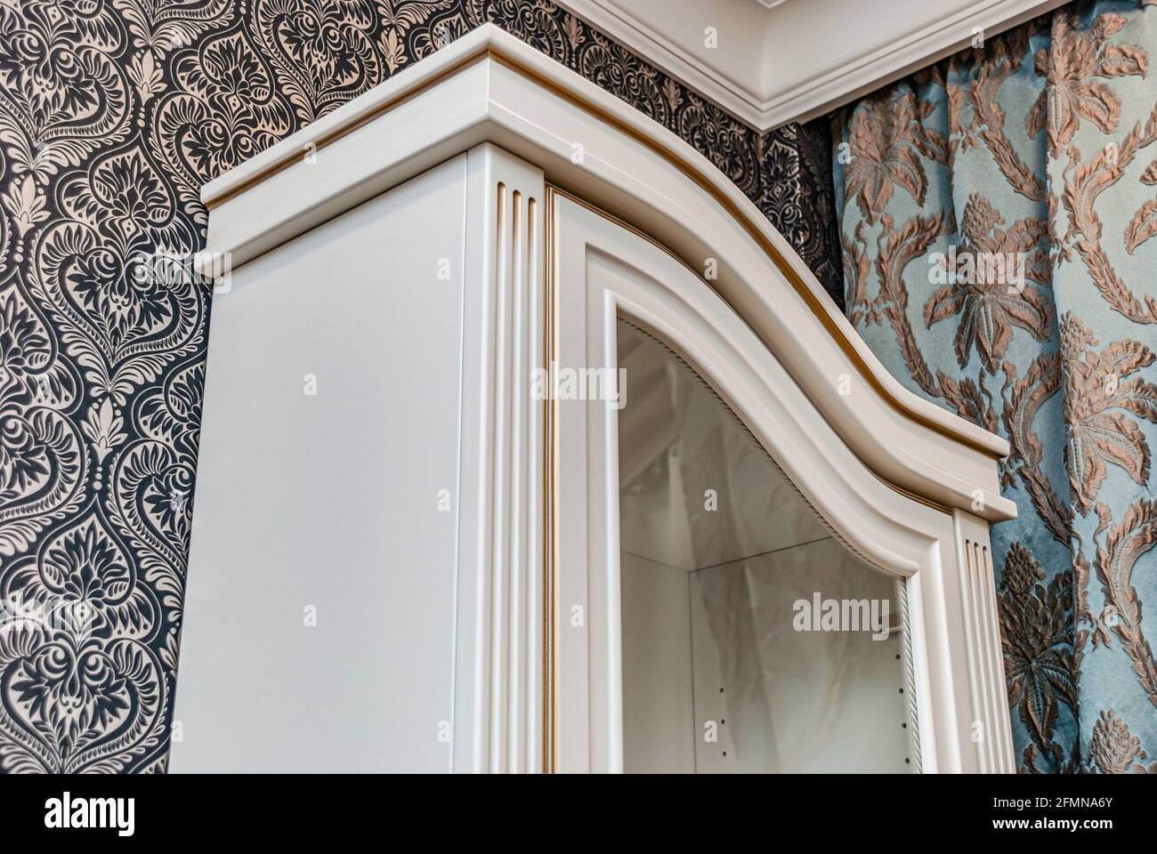 Classical style white showcase with glass doors and gilding on the