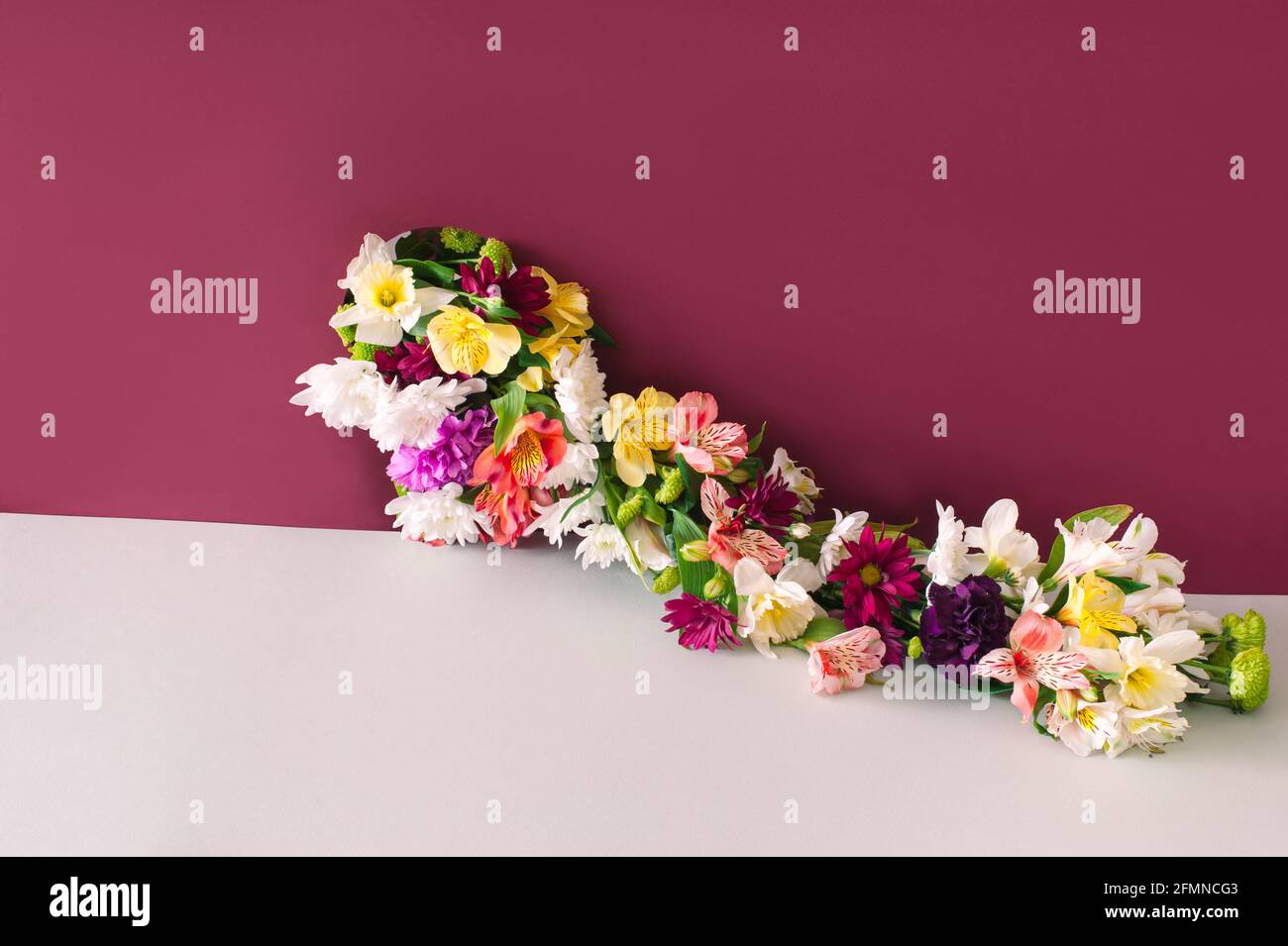 Creative layout with colorful flowers from the hole over beige background.  Concept of taking what you need in minimal style. Stock Photo
