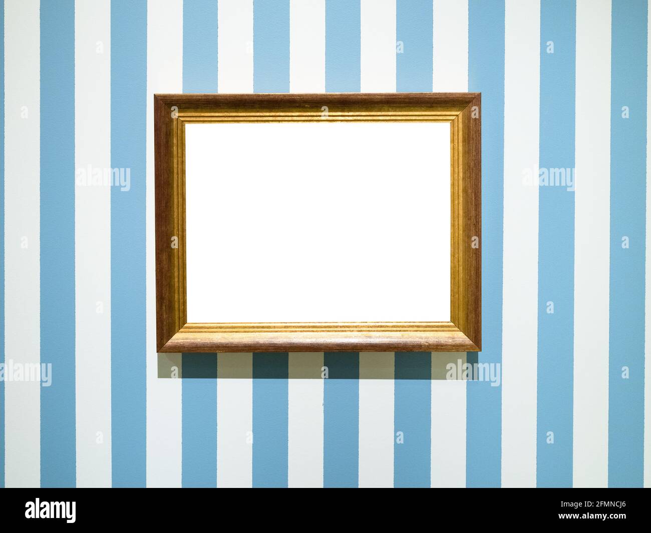 gold painted wooden picture frame with cutout canvas on blue striped wall Stock Photo