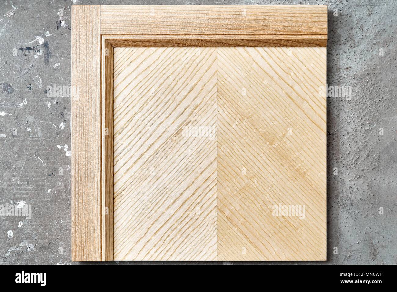 Stylish new detail of furniture facade made of light veneer and solid textured ash wood on concrete floor background view from above Stock Photo