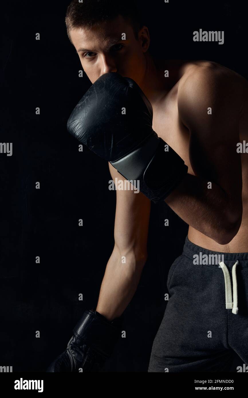 boxer in black gloves lean forward on isolated background cropped view