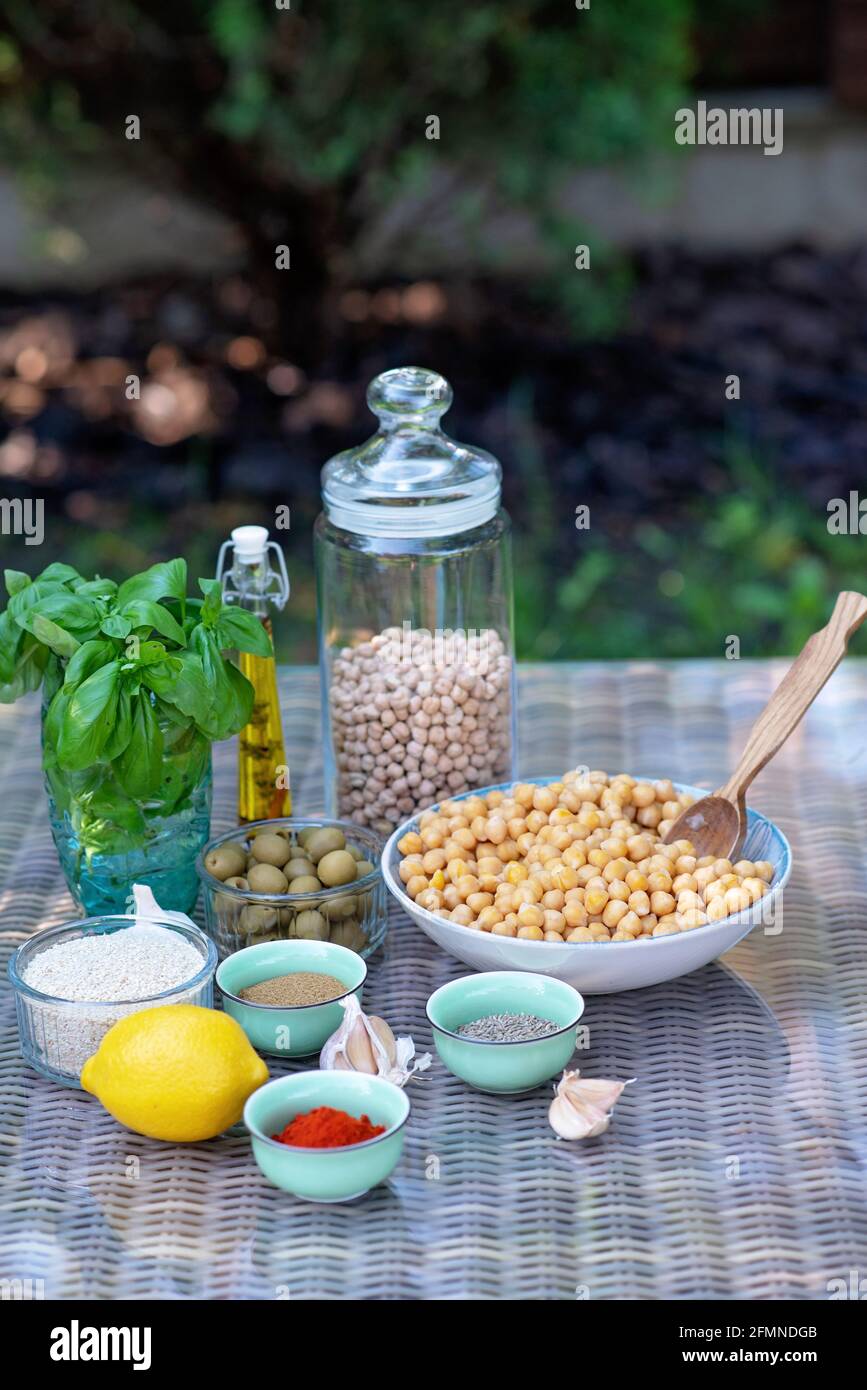A set of ingredients for the preparation of hummus snacks: chickpeas, tahini, spices, garlic, parsley, olive oil . Recipe for a vegetarian Mediterrane Stock Photo