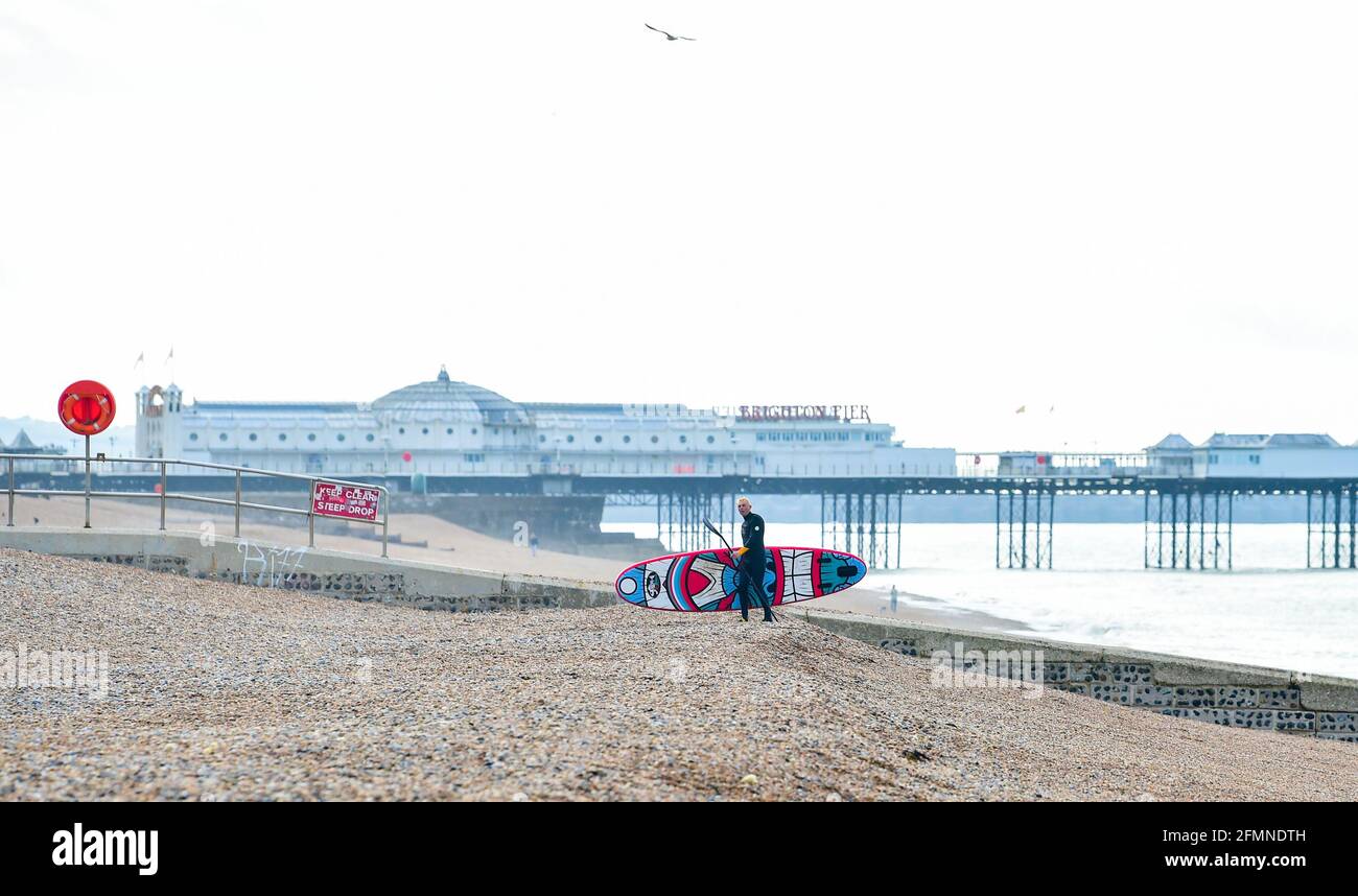 Brighton UK 11th May 2021 - A paddle  boarder enjoys the  warm sunny morning in Brighton as a mixture of sunshine and showers are forecast for the UK today : Credit Simon Dack / Alamy Live News Stock Photo
