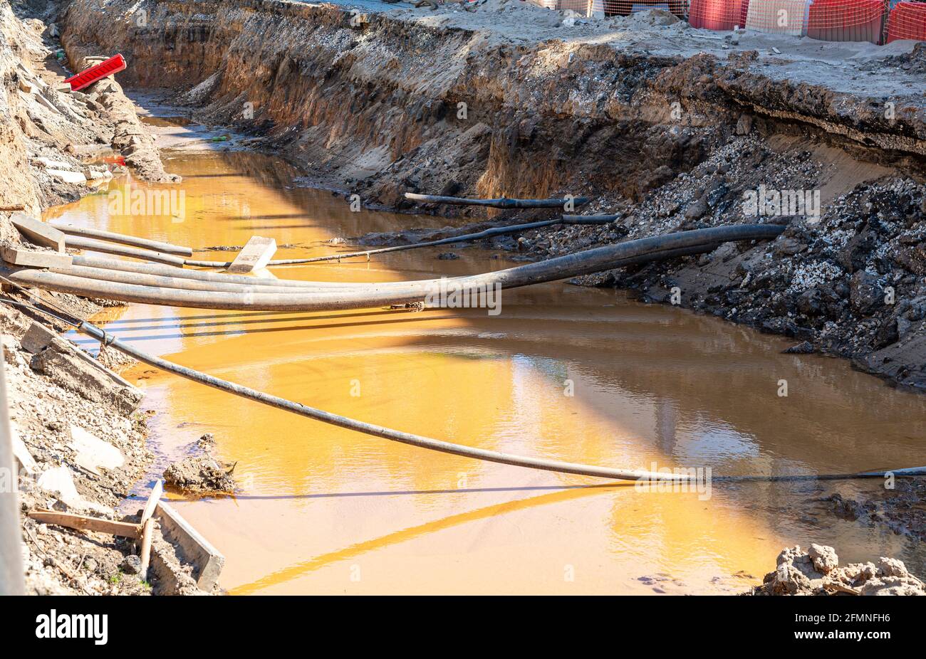 Construction works on iron pipes at a depth of excavated trench Stock