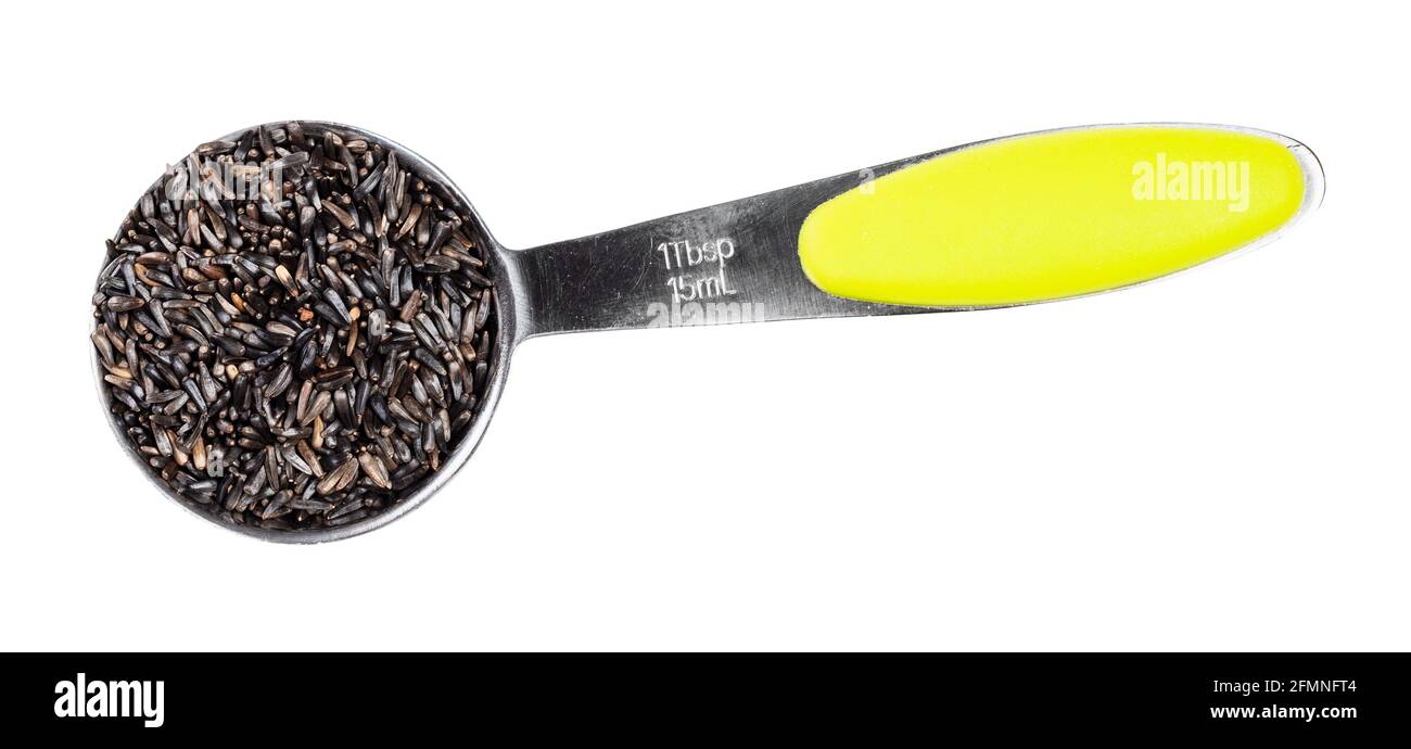 top view of niger seeds (Guizotia Abyssinica) in measuring tablespoon cutout on white background Stock Photo