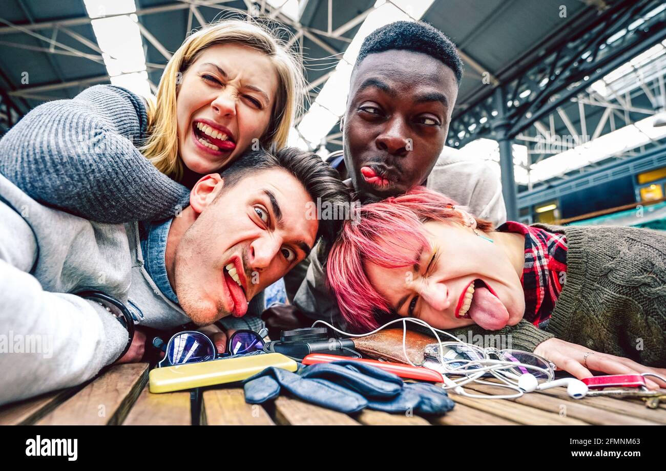 Drunk friends taking selfie with crazy funny faces at indoor event - Happy friendship concept on millenial people having fun together Stock Photo