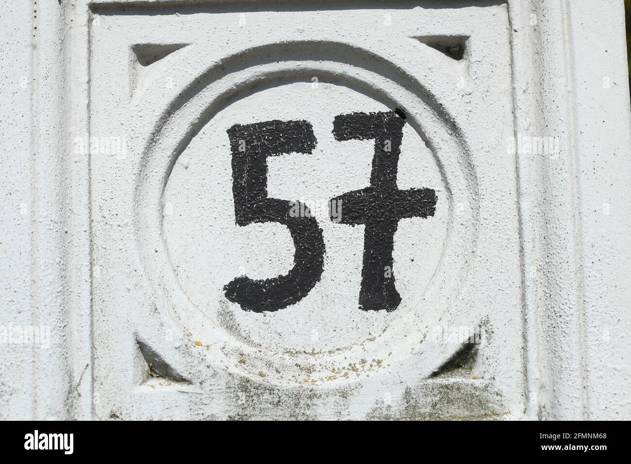 Schwarzes Hausnummernschild Nr. 57 auf weissem Untergrund, Deutschland, Europa Stock Photo