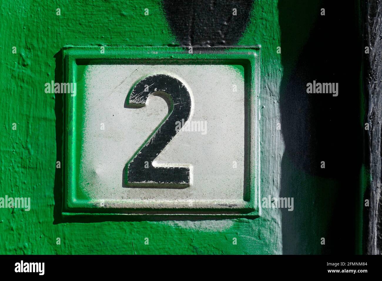 Hausnummernschild Nummer Zwei auf  grüner Hauswand, Deutschland, Europa Stock Photo