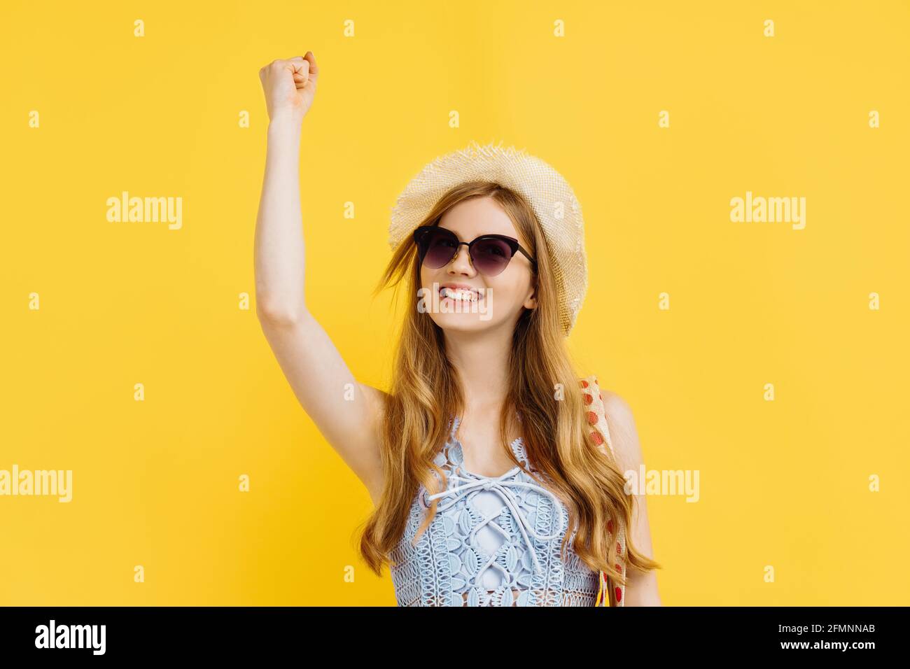 Happy young woman in sunglasses and summer hat celebrating victory over ...