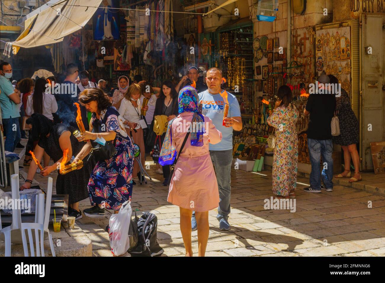 Jerusalem, Israel - May 01, 2021: Pilgrims passing on the Holy Fire, on Holy Saturday (Easter), in the alleys of the Old City around the Holy Sepulchr Stock Photo